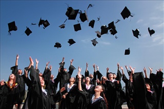 New graduates throwing their hats and tassels into the air.