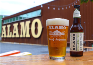 Picture of a Alamo draft house brew in front of one of it's locations.