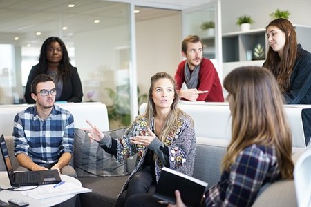 A group of young people talking at work.